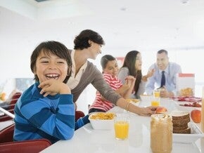 Familia el desayuno juntos en la cocina, sentados alrededor de la mesa.