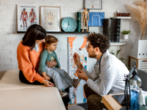 Pediatra revisando a niña con estomatitis
