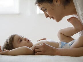 Mamá y bebé en pañales acostado en la cama.