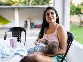 Madre sentada amamantando a un bebé