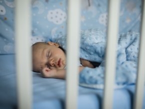 Bebé durmiendo plácidamente en una cuna, con la boca ligeramente abierta.