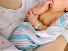 Mamá sosteniendo a un bebé recién nacido con ictericia neonatal.