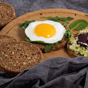 Huevo sobre pan de linaza y salsa cremosa de albahaca