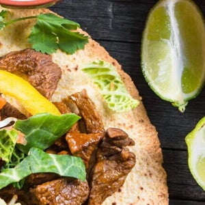 Fajitas rellenas con res y una salsa con limones a un lado