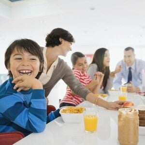 Familia el desayuno juntos en la cocina, sentados alrededor de la mesa.