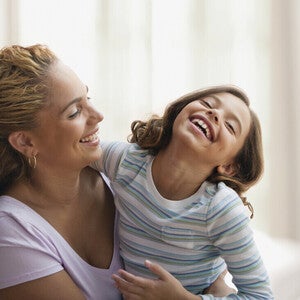 Mamá y niña de preescolar riendo al decir trabalenguas