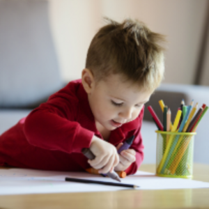 Niño pequeño coloreando una hoja blanca