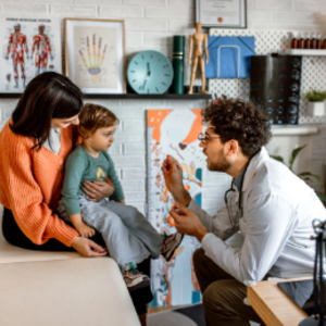 Pediatra revisando a niña con estomatitis