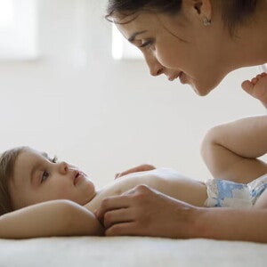 Mamá y bebé en pañales acostado en la cama.