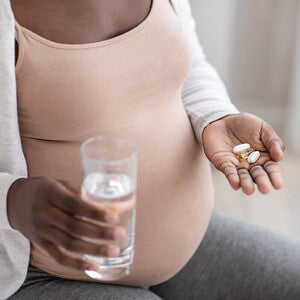 Mujer embarazada tomando vitaminas prenatales