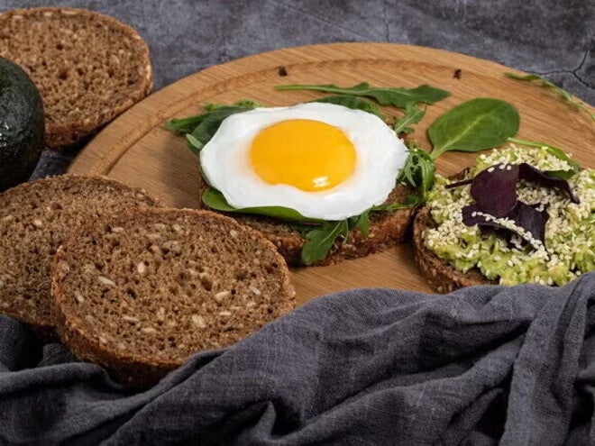 Huevo sobre pan de linaza y salsa cremosa de albahaca