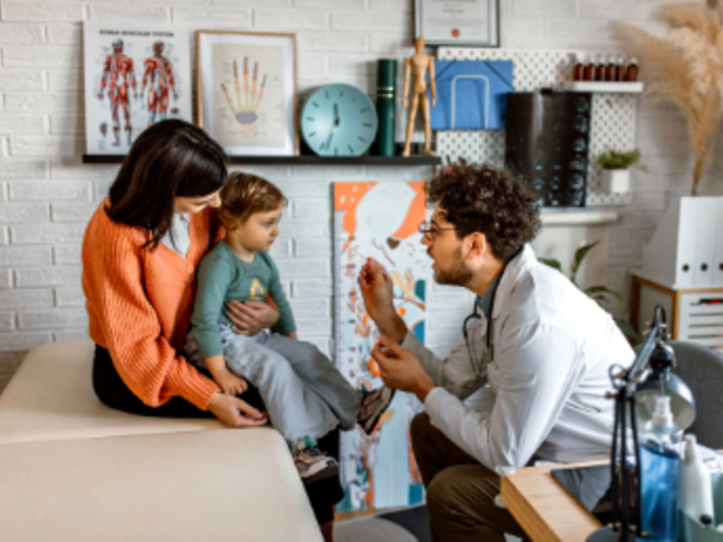 Pediatra revisando a niña con estomatitis