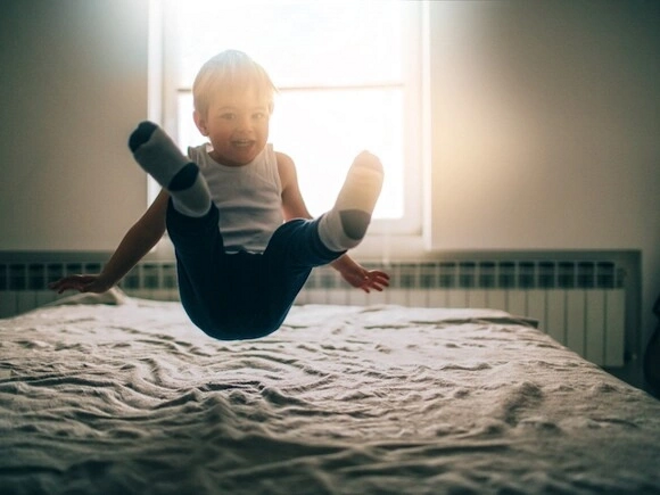 Estimulación temprana para bebés y niños niño saltando sobre la cama