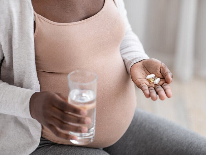 Mujer embarazada tomando vitaminas prenatales