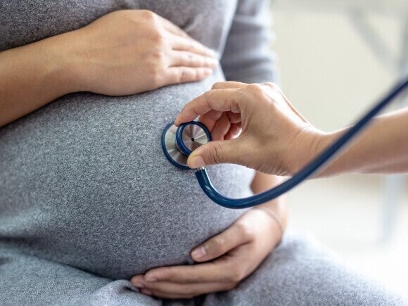 Médico revisando a una mujer embarazada durante una consulta prenatal
