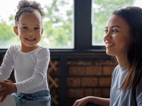 Apoyo familiar a niños con Apraxia del Habla Infanti Madre y niña pequeña jugando y riendo.