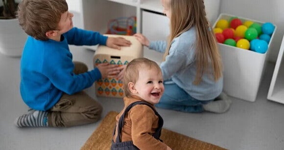 Apraxia del Habla Infantil Niños pequeños riendo y jugando en un cuarto de juegos.