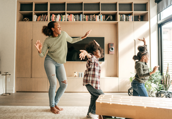Niños y tía en la sala jugando y bailando