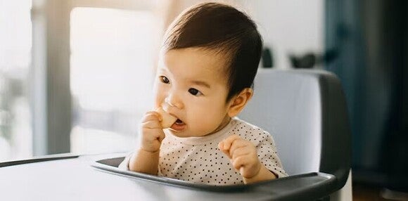 Niña comiendo galletas para bebés.