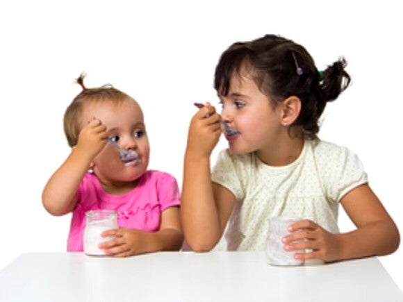 Importancia de snacks saludables para niños Bebé y niña pequeña comiendo un snack.